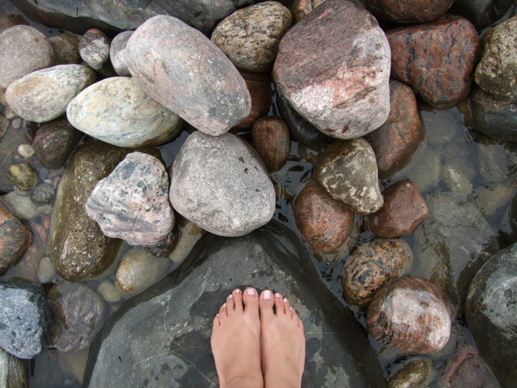feet on rocks with water